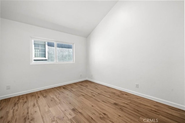 unfurnished room featuring vaulted ceiling and light wood-type flooring