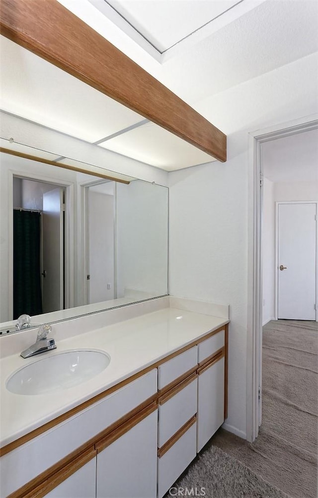 bathroom featuring vanity and beamed ceiling