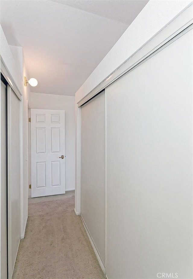 hallway featuring light colored carpet