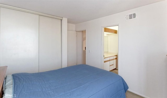 carpeted bedroom featuring connected bathroom and a closet