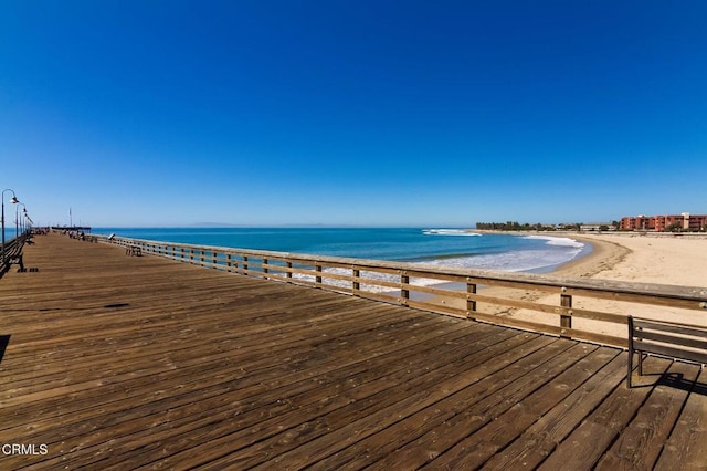 view of dock with a view of the beach and a water view