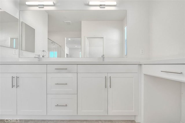 bathroom with walk in shower and vanity