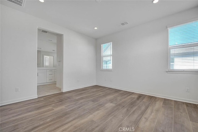 empty room featuring plenty of natural light and light hardwood / wood-style flooring