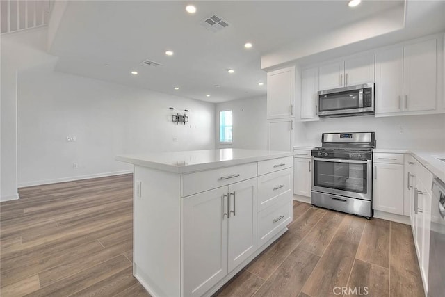 kitchen with a kitchen island, white cabinets, and appliances with stainless steel finishes