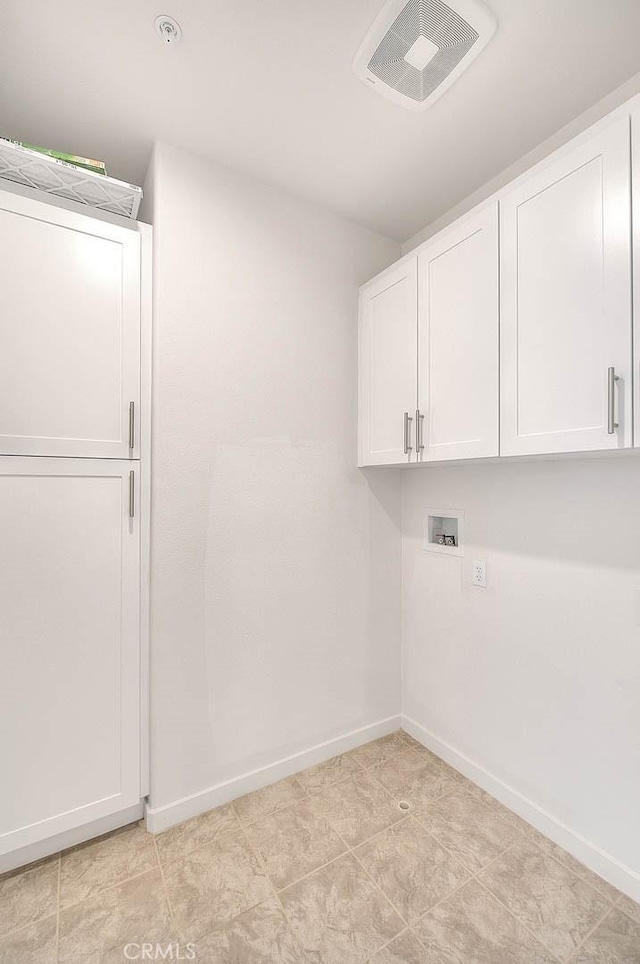 laundry area featuring cabinets, hookup for a washing machine, and light tile patterned floors