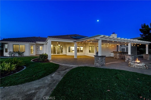 back of property with a fire pit, a patio, stucco siding, and a pergola