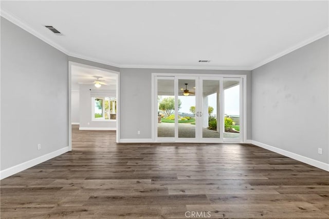 unfurnished room featuring dark wood-style flooring, visible vents, and crown molding