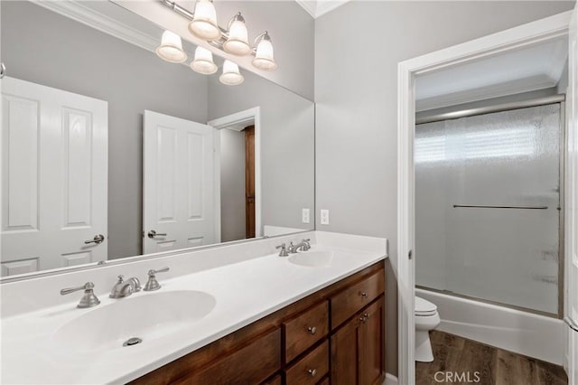 bathroom with wood finished floors, a sink, toilet, and double vanity