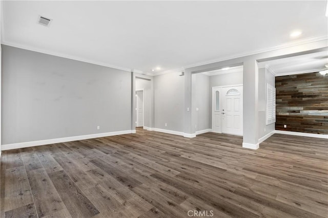 unfurnished living room featuring crown molding, wood finished floors, visible vents, and baseboards