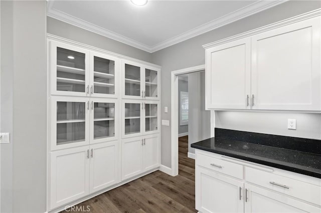 kitchen with ornamental molding, white cabinets, dark wood finished floors, and glass insert cabinets