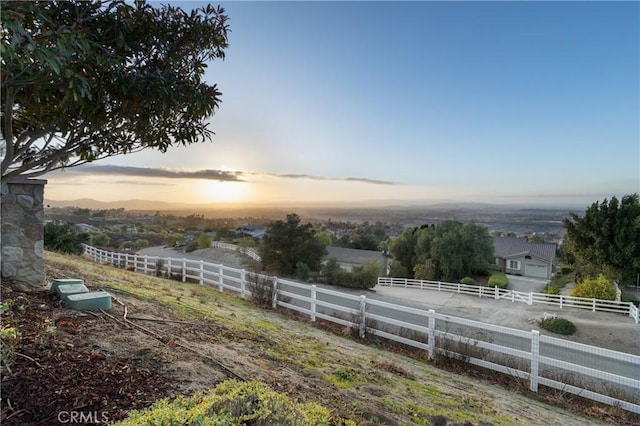 yard at dusk with fence and a rural view