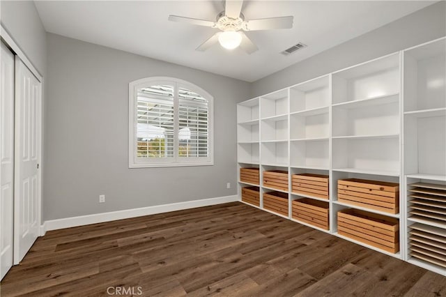 unfurnished bedroom with ceiling fan, wood finished floors, visible vents, baseboards, and a closet