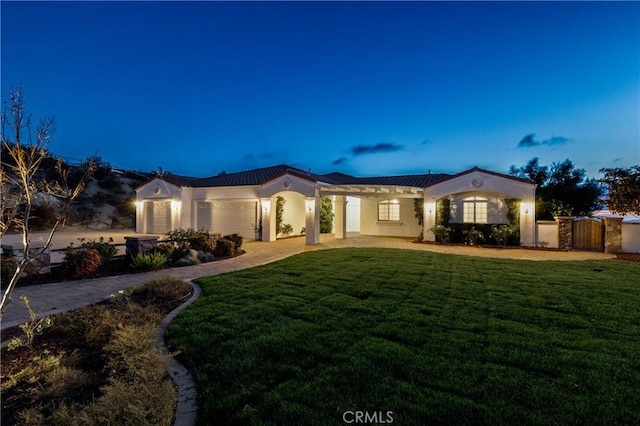 mediterranean / spanish-style house featuring a garage and a yard