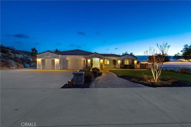 view of front of property featuring a garage, a lawn, and concrete driveway