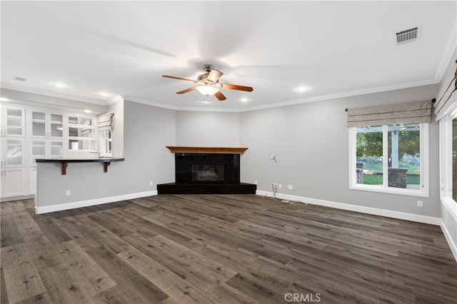 unfurnished living room with baseboards, visible vents, dark wood finished floors, and a glass covered fireplace