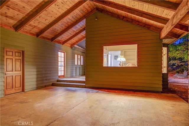 interior space featuring wooden ceiling, vaulted ceiling with beams, and wooden walls