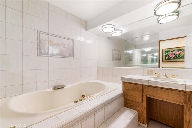 bathroom with a jetted tub, vanity, and tile walls