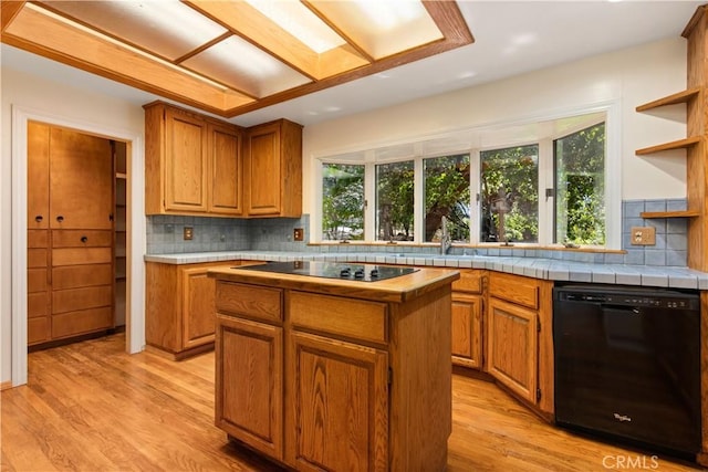 kitchen with black appliances, light wood-type flooring, open shelves, and a center island