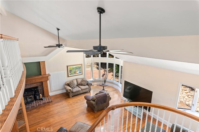 living area with visible vents, vaulted ceiling, and wood finished floors