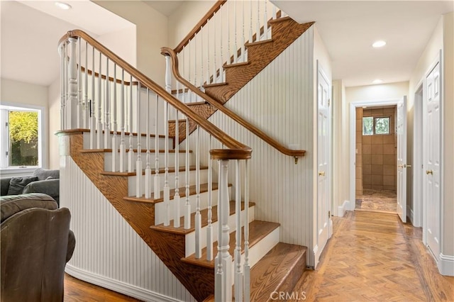 stairs with recessed lighting, parquet floors, and plenty of natural light