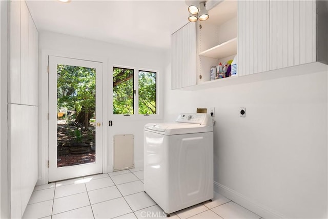 laundry area with washer / dryer, light tile patterned floors, baseboards, and cabinet space