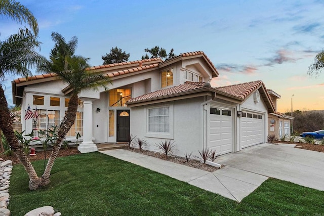 view of front of home with a garage and a lawn