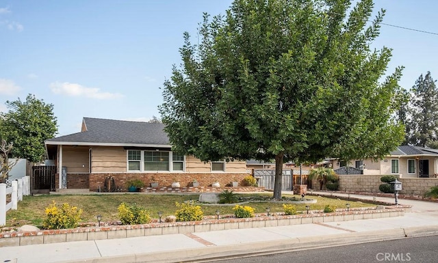 view of property hidden behind natural elements featuring a front yard