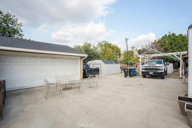 view of patio / terrace featuring a storage unit and a garage