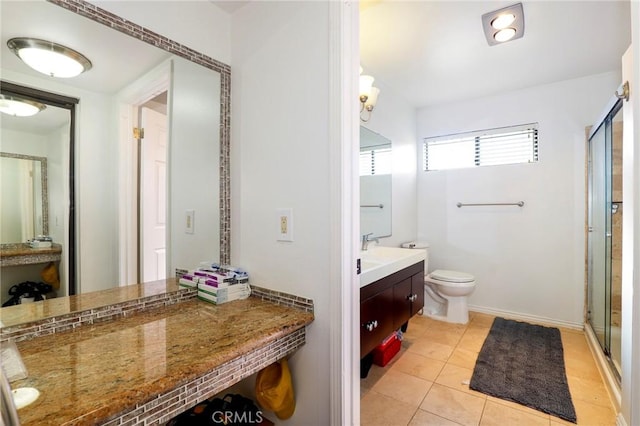 bathroom with vanity, a shower with shower door, tile patterned floors, and toilet