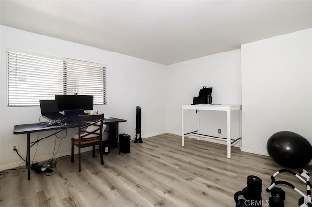 home office with light hardwood / wood-style flooring