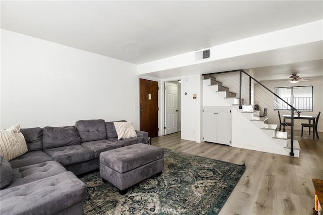 living room featuring wood-type flooring and ceiling fan