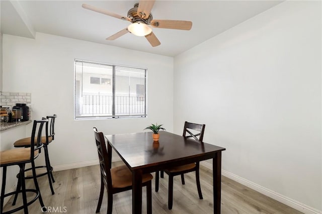 dining space with ceiling fan and light wood-type flooring