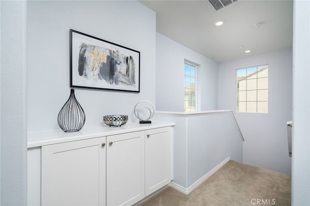 hallway featuring light colored carpet