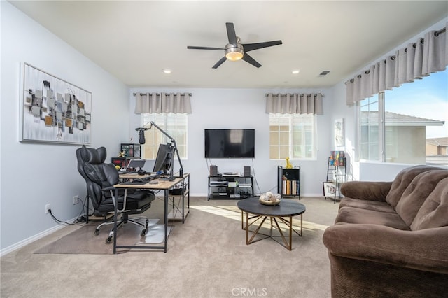 carpeted office space featuring plenty of natural light and ceiling fan