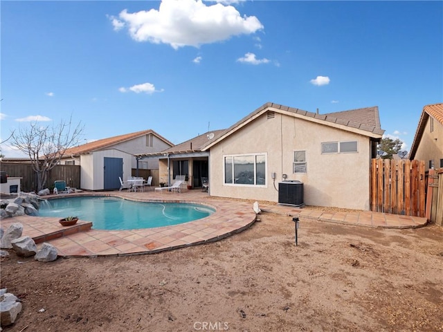 view of swimming pool with central AC, pool water feature, a patio area, and a shed