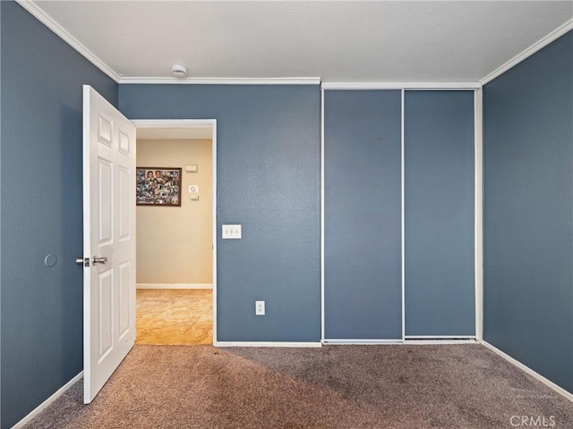 unfurnished bedroom with crown molding, a closet, and carpet flooring