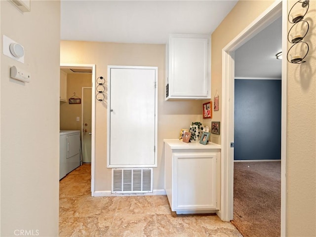 kitchen with washer and dryer and white cabinets