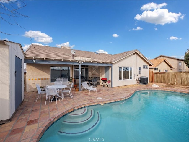 back of house with central AC unit, a patio area, and a fenced in pool