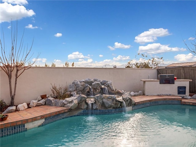 view of swimming pool with pool water feature