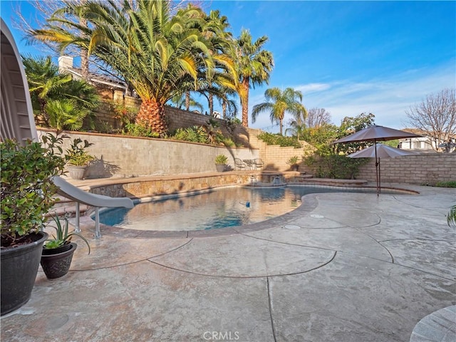 view of swimming pool with a water slide and a patio area