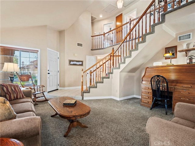 carpeted living room featuring a towering ceiling