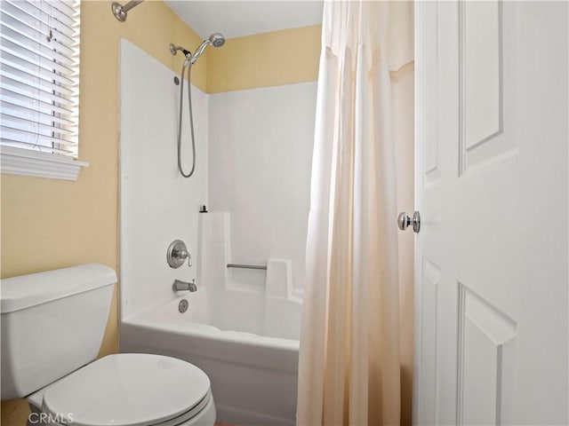 bathroom with shower / bath combination with curtain and toilet