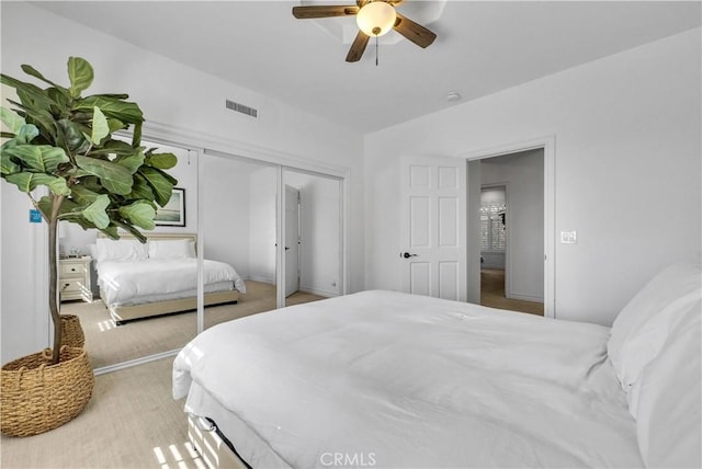 bedroom featuring a ceiling fan, a closet, visible vents, and vaulted ceiling