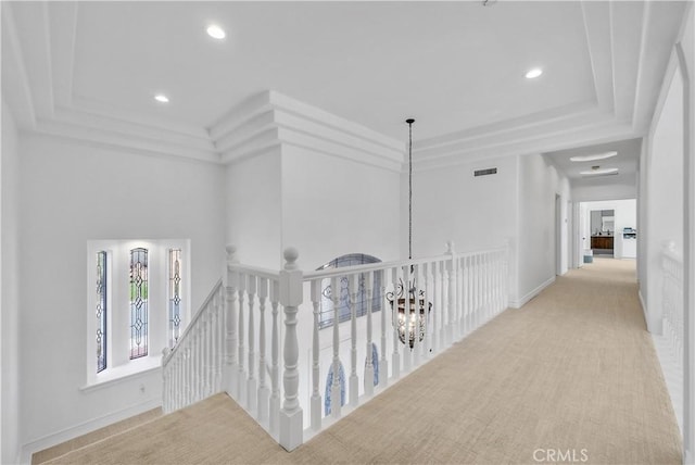 corridor featuring baseboards, visible vents, a raised ceiling, an upstairs landing, and recessed lighting