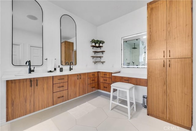 bathroom with double vanity, a shower stall, a sink, and tile patterned floors