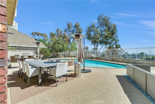 view of swimming pool with a patio, outdoor dining space, fence, and a fenced in pool