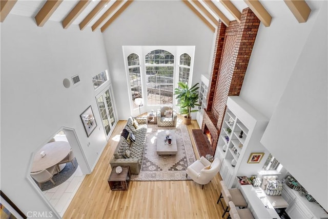 living area with visible vents, high vaulted ceiling, wood finished floors, and beamed ceiling