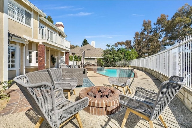 view of pool with a patio area, fence, a fire pit, and a fenced in pool