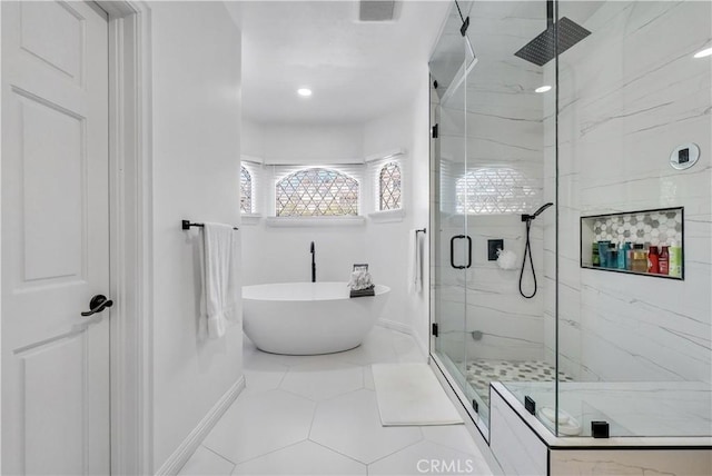 full bath featuring a marble finish shower, visible vents, baseboards, a soaking tub, and tile patterned floors