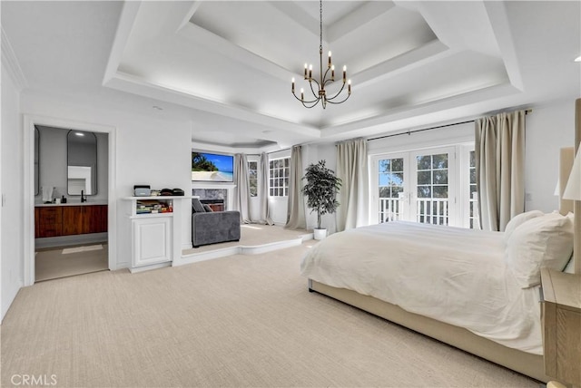 carpeted bedroom with ensuite bath, access to exterior, a tray ceiling, french doors, and a fireplace